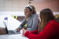 Twee studenten werken samen aan een laptop op de campus